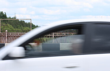 View of the metal fence of the bridge through the window of a moving car