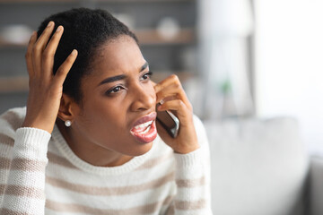 Unpleasant Call. Portrait Of Frustrated Black Female Talking On Cellphone At Home