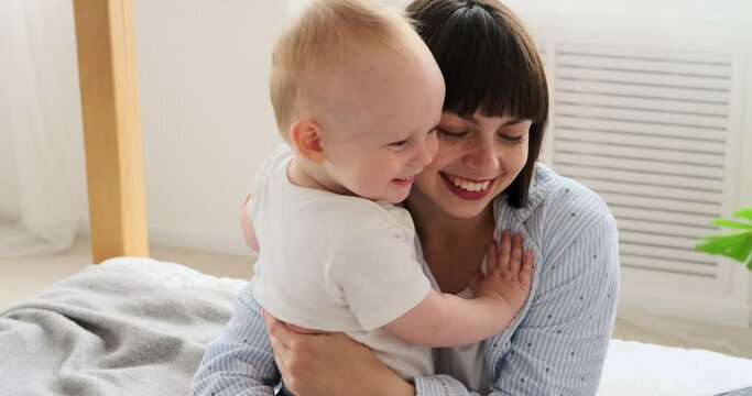 Parents spending leisure time with baby son on bed at home