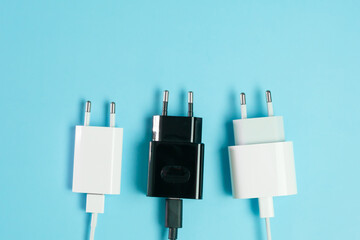 Power plugs with USB A and USB type C connectors from smartphone charger on the blue background...