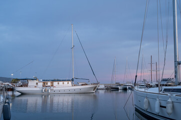 Fototapeta premium Yacht and boats parking in harbor. White sailing yachts at the pier. Sea yacht club. Aegean sea. Athens, Greece. Twilight.