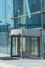 Vertical shot revolving carousel rotary doors at entrance to building of shopping center, office,...