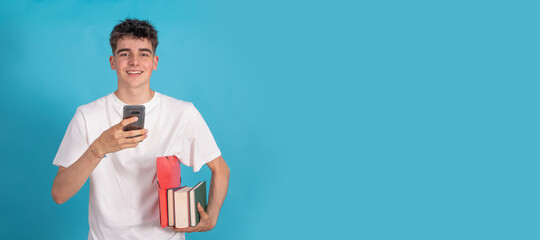 smiling student with mobile phone and books isolated on color background