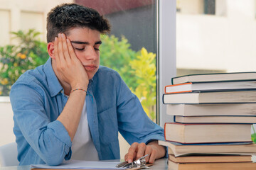 tired or stressed student at the desk with books
