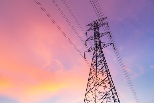 Horizontal silhouette of electric pole with purple blue sky in the evening.