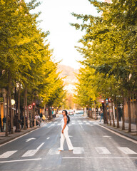 Lifestyle of a young girl of black African ethnicity with pants and a white t-shirt. Visiting the city across the street at a zebra crossing