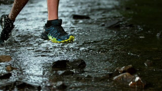 Super slow motion of man foot running in river, splashing around. Filmed on high speed cinema camera, 1000 fps.