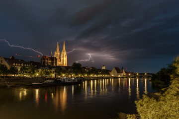 Gewitter über Regensburg am Abend mit Blitzen und Dome beleuchtet