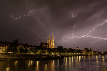 Gewitter über Regensburg am Abend mit Blitzen und Dome beleuchtet