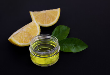 Lemon slices and cosmetic lemon oil on a black background. Close up