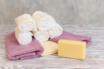 Stack of spa terry towel and soap bar on wooden table