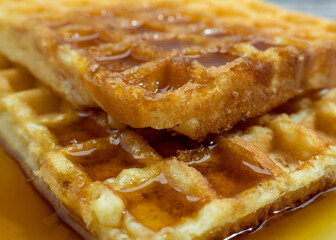 Freshly baked waffles in syrup for breakfast.