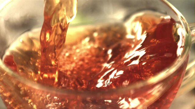 Super slow motion tea pours into the cup whirlpool. Macro background.Filmed on a high-speed camera at 1000 fps. 
