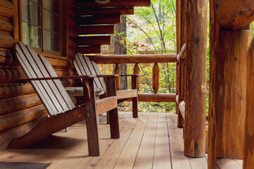 Front Porch of Rustic Log Cabin with Wooden Adirondack Chairs