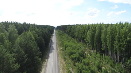 Fototapeta na wymiar Aerial view of the road in the forest on a summer sunny day