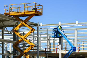mobile self propelled hydraulic lifting platform and scissor lift in action - obrazy, fototapety, plakaty