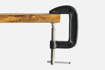 Metal Clamp tool on Wood on background.