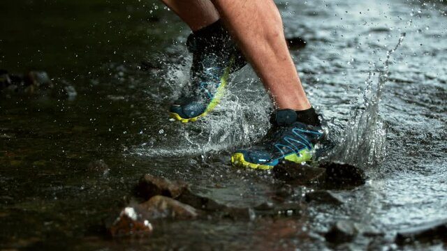 Super slow motion of man foot running in river, splashing around. Speed ramp effect. Filmed on high speed cinema camera, 1000 fps.