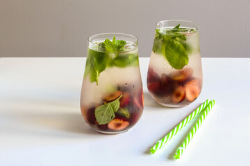 Cold drinks in a glass. Cherries mint lemonade. Mojito coctail. Summer iced refreshment drink.