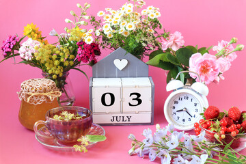 Calendar for July 3 : the name of the month of July in English, cubes with the numbers 0 and 3, a cup of tea, bouquets of flowers, an alarm clock, berries on a pink background