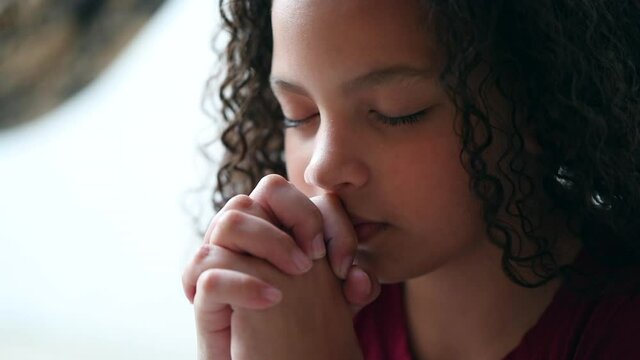 Little girl praying to God, spiritual child in prayer