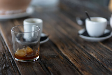 woman with rings and watch having a cup of coffee at wooden table