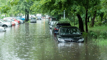 Flooded cars on the street of the city. Street after heavy rain. Water could enter the engine, transmission parts or other places. Disaster Motor Vehicle Insurance Claim Themed. Severe weather concept - obrazy, fototapety, plakaty