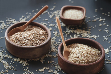 Set of different types of rice and cereals in wooden bowls and