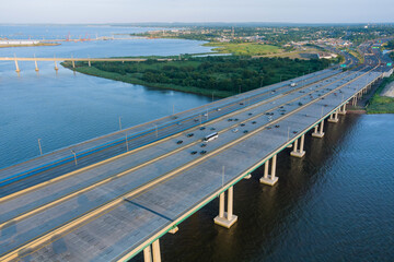 Obraz premium Aerial top view of huge complex road junction at cars driving on the Alfred E. Driscoll Bridge across the Raritan River New Jersey