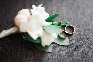 Wedding rings and a bouquet of roses and other flowers