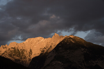 la bella atmosfera di un tramonto in montagna dove le nuvole si colorano di un'arancione intenso