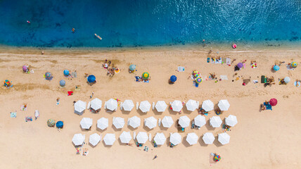 Aerial. Sandy beach with tourists by the sea. Top view from drone.