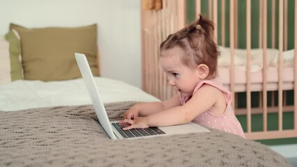 Childcare at Home, Child Protection, New Life, Leisure with Baby. Funny kid typing on laptop at home on bed
