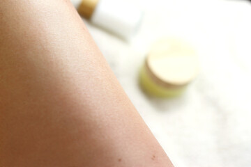Epilation, leg skin close up with bottles of cream 