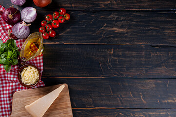 Wooden background with ingredients for pizza. Gray wood with red checkered napkin. Copy space. Top view