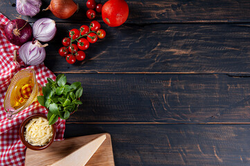 Wooden background with ingredients for pizza. Gray wood with red checkered napkin. Copy space. Top view