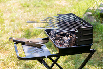 Garden barbecue outdoors where the charcoal is burning. The grid is empty