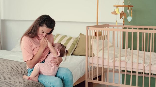 Childcare at Home, Child Protection, New Life, Leisure with Baby. Mom breastfeeds the baby at home in the bedrooms