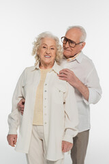 elderly man in casual clothes hugging wife looking at camera isolated on white