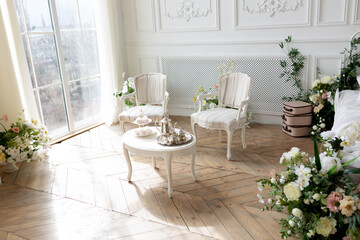 interior - white suite by the window. furniture in classic style. tea table by the window
