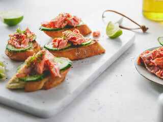 Toasts with smoked salmon and fresh cucumber served with lime shavings.