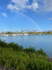 Fototapeta na wymiar Rainbow over boat harbor in Hawaii