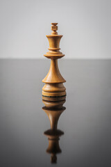 
the king chess piece on white background with reflection in table