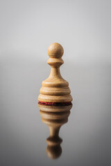 the pawn chess piece on white background with reflection in table