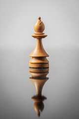 the bishop chess piece on white background with reflection in table.