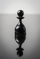 the pawn chess piece on white background with reflection in table