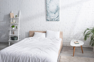 Fototapeta na wymiar bed with white bedding in modern bedroom
