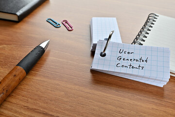 There is a word book with the word User Generated Contents written on it with a pen and paper clips.