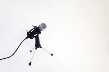 small microphone with a stand on a white background. place for your text. sound and voice concept.