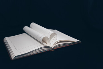 expanded diary with heart-shaped pages. notebook on a black background. love of books